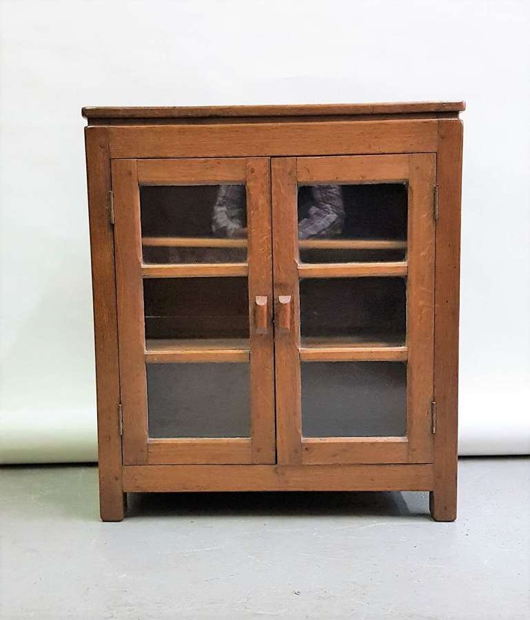 Mouseman style oak glazed dwarf cabinet